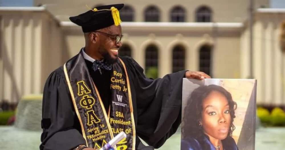 Black Man poses with a photo of a family member as he becomes a lawyer.