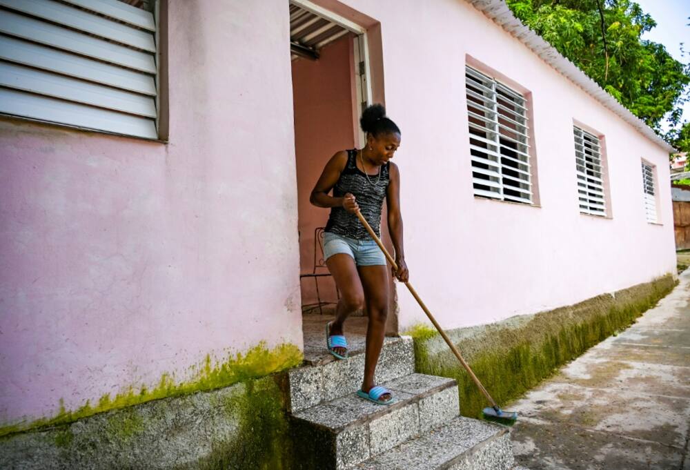 Isabel Hernandez, whose son was detained for taking part in anti-government protests, sweeps the stairs of her new house in Havana's La Guinera neighborhood in June 2022