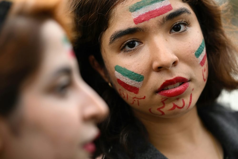 A protester in Nantes in France has her face painted with an Iranian flag in support of Kurdish woman Mahsa Amini on Monday