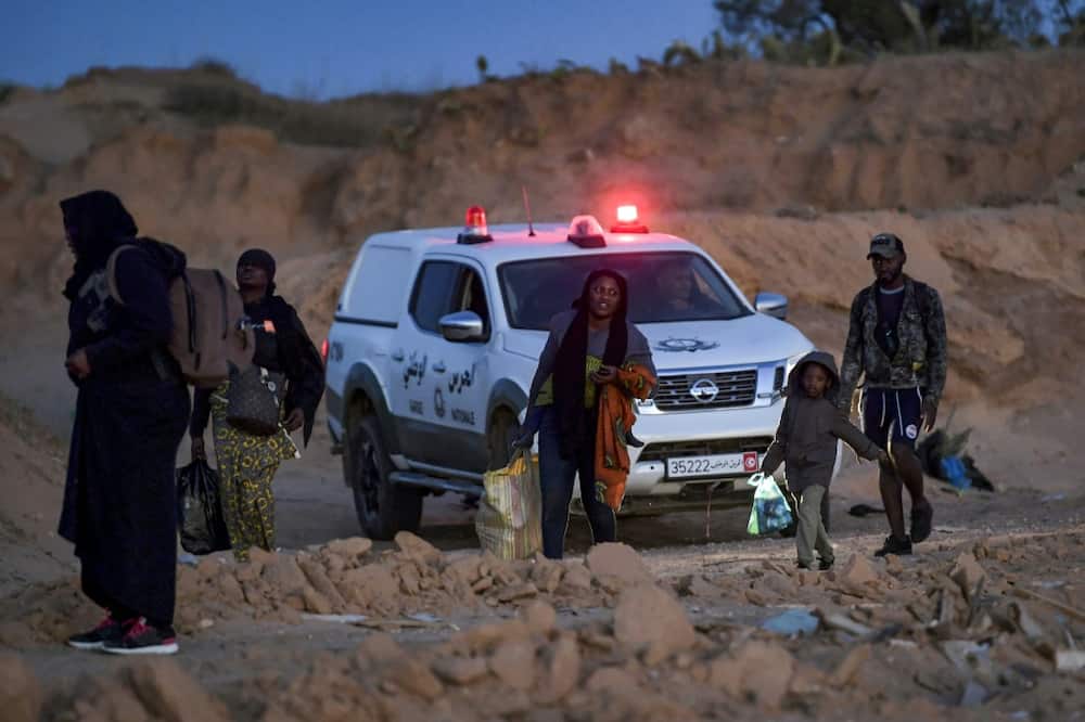 Members of Tunisia's National Guard clear migrants from an olive grove  by the sea north of Sfax, suspecting them of preparing to board a vessel leaving clandestinely for Italy