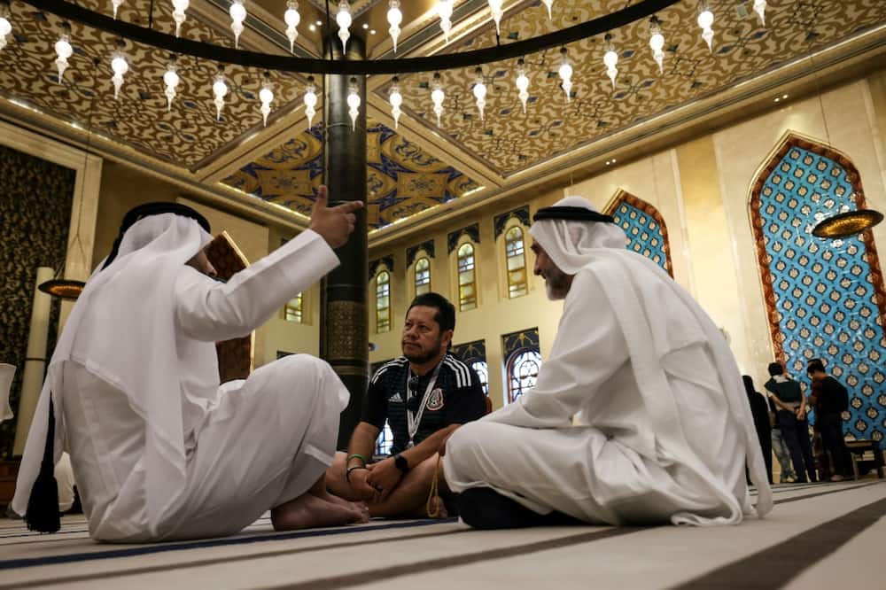 A football fan chats with Gulf residents inside the Blue Mosque