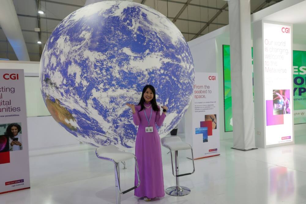 A delegate poses for a picture in an exhibitions pavilion at the convention center hosting the COP27 climate conference