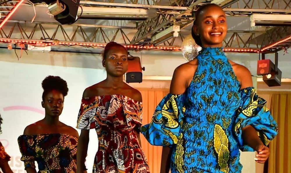 Three models wearing Ankara outfits are in a runway fashion show