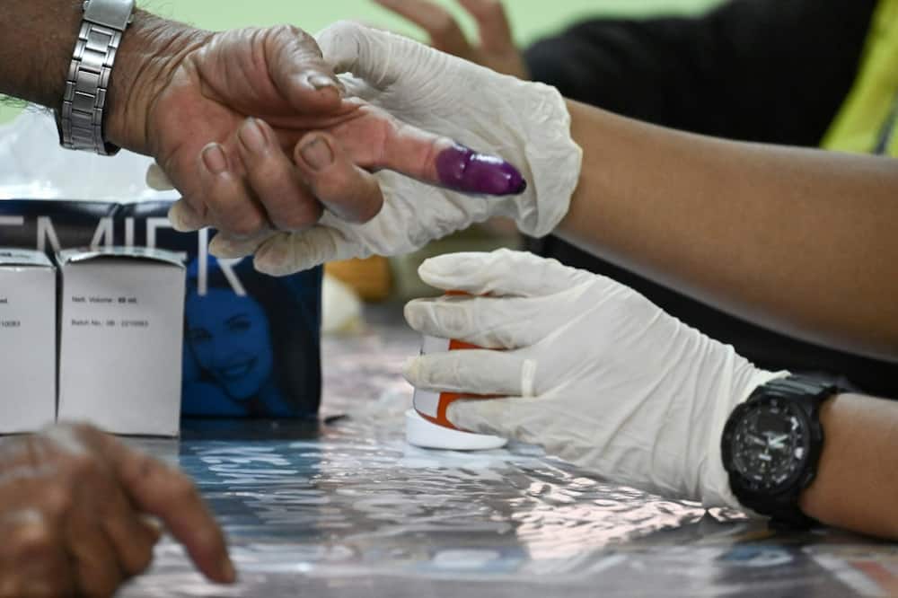 A man gets his finger inked before casting his ballot at a polling station in Bera, Malaysia on Saturday