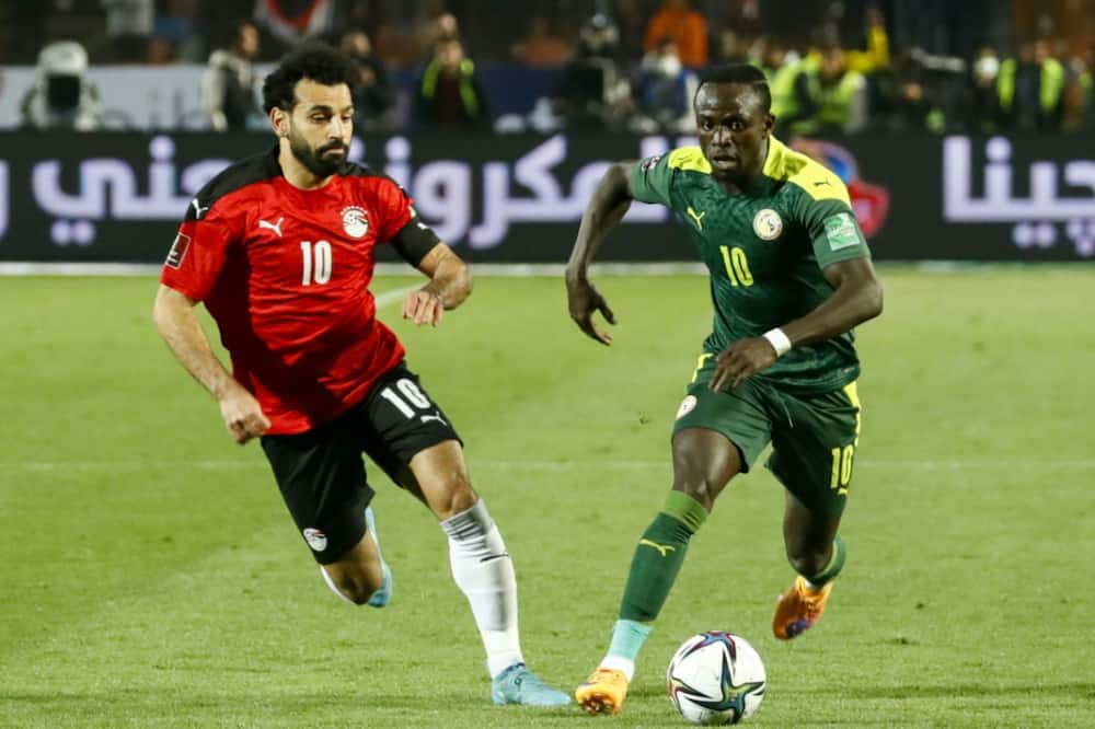 Egypt captain Mohamed Salah (L) chases Senegal star Sadio Mane (R) during a World Cup play-off in Cairo on March 25, 2022.