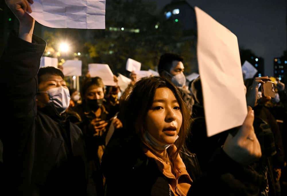 Protesters march along a street during a rally for the victims of a deadly fire as well as a protest against China's harsh Covid-19 restrictions