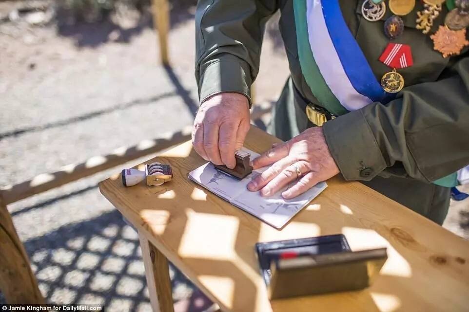 President Baugh stamps passports of visitors. Photo: Daily Mail/Jamie Kingham