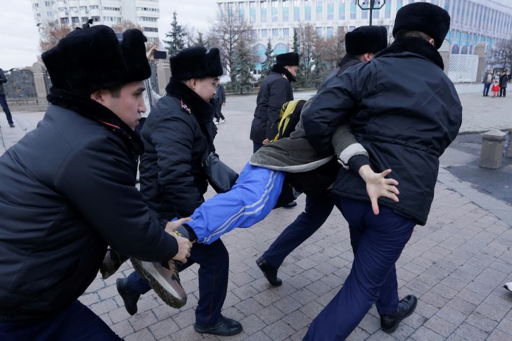 Kazakh police detain a protester at a rally during Sunday's presidential election