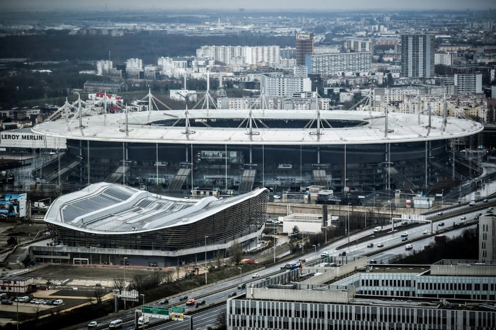 The Olympic Aquatics Centre (foreground), the renovated Stade de France and the footbridge that will join them have added to the bill for Paris