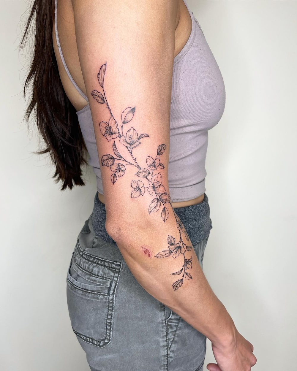 Woman with Bougainvillea floral wrap tattoo on arm