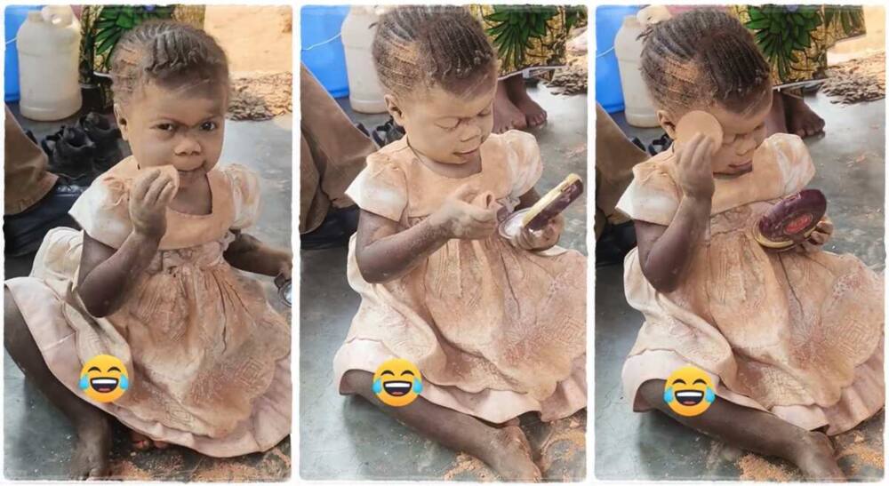 A little girl using brown powder on her face.