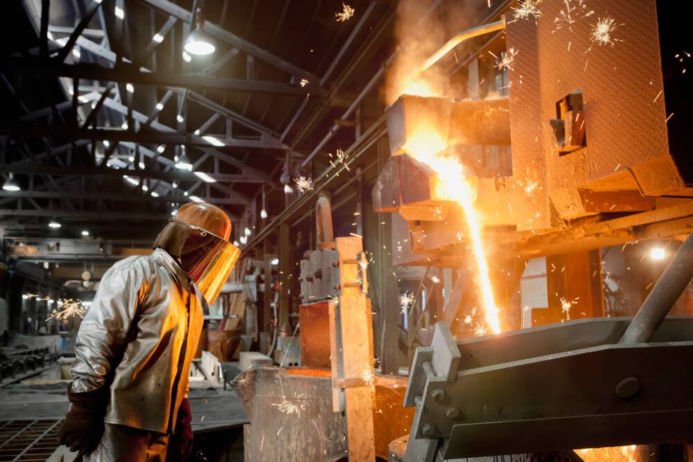 A steel worker is burning steel