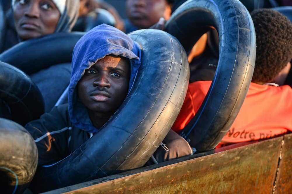 Migrants clutch the inner tubes of truck tyres, their sole protection in the event of shipwreck on the perilous sea crossing