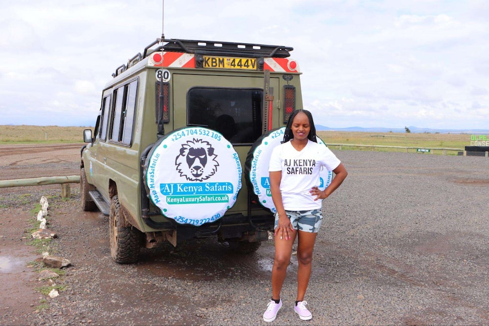 Woman standing behind an AJKenya Safaris vehicle