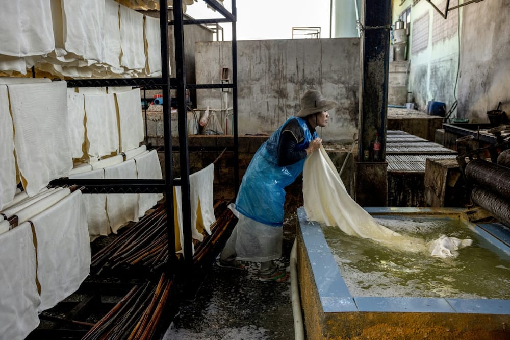 Factory workers process natural rubber sheets at the Klongpan rubber cooperative in Trang province