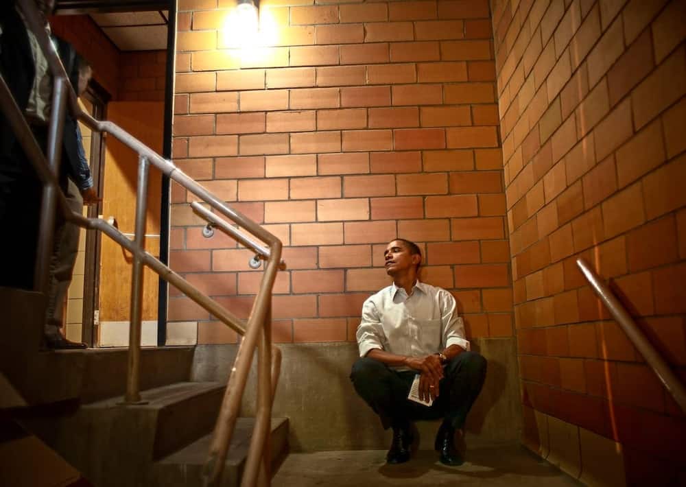 Obama listens from a back stairwell as he being introduced