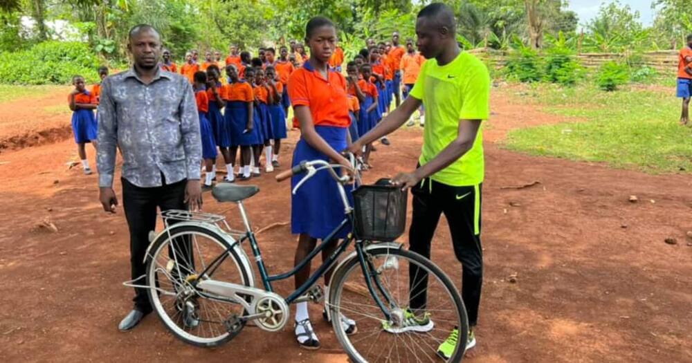 Saddick Adams delivers a bike to Maa Abena Tawia.