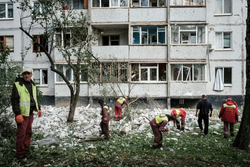 Workers remove debris from a residential building hit by a missile in Kharkiv