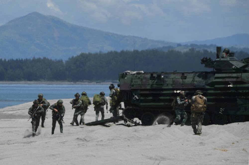 Philippine and US marines disembark from amphibious assault vehicles during a joint landing exercise at a beach