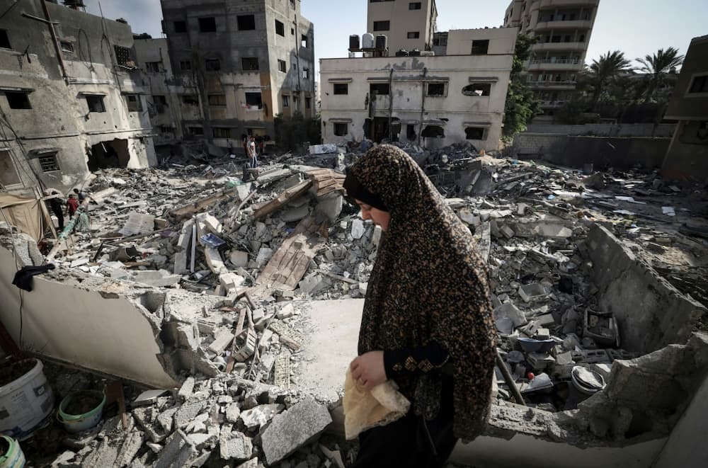 A Palestinian woman surveys the rubble of her home in Gaza City after a ceasefire halted three days of Israeli air strikes and retaliatory rocket fire by militants