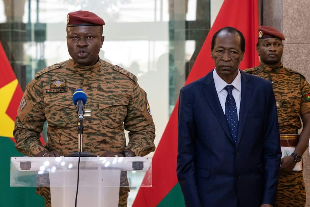 Burkina Faso's new strongman, Lieutenant-Colonel Paul-Henri Sandaogo Damiba (L), speaks flanked by former president Blaise Compaore (R)