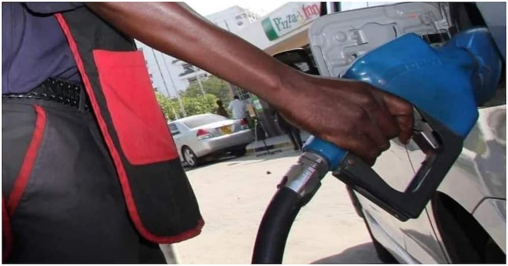 A petrol attendant pumping fuel into the car.