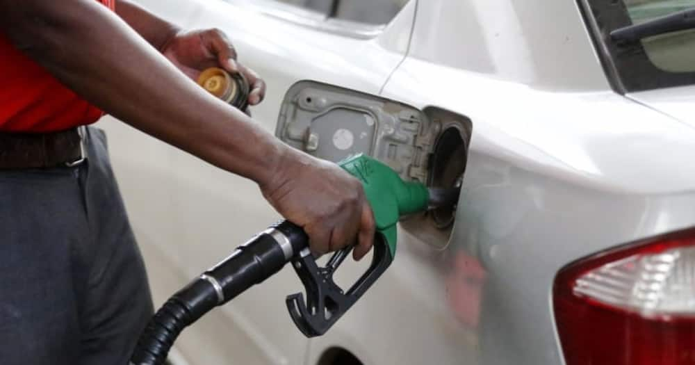 A petrol attentant filling petrol into the car.