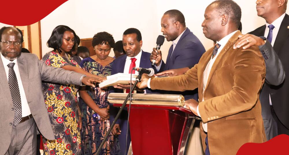 Reuben Kigame (in a red tie) being prayed for ahead of the launch of his book in 2023.
