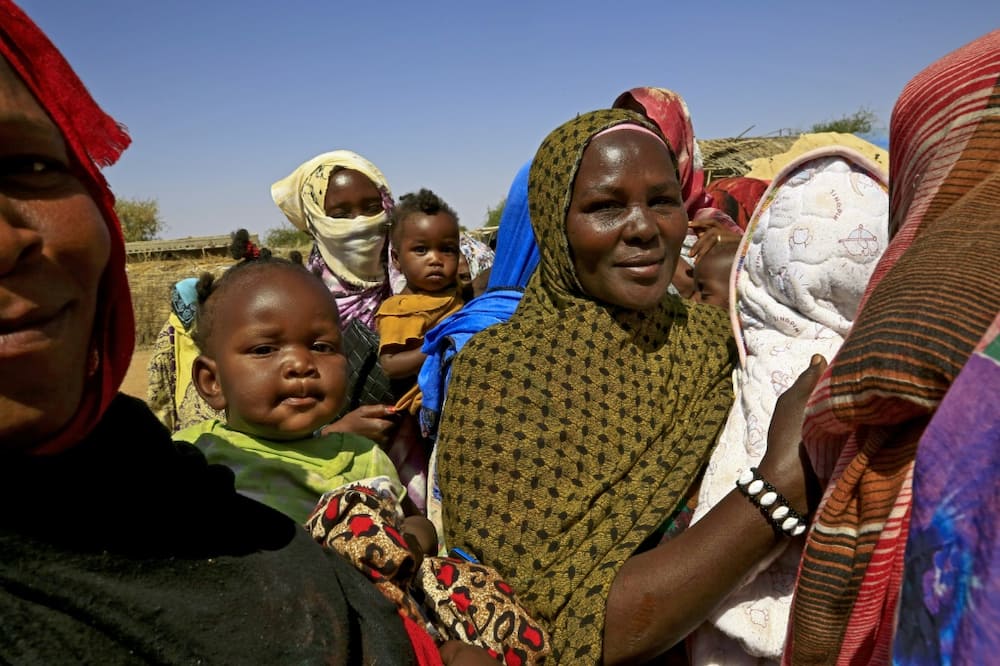 Increasing demands on dwindling natural resources has fuelled inter-ethnic conflicts in Sudan: here Sudanese women wait for the arrival of World Food Programme (WFP) aid at a camp for displaced people in South Darfur in February 2021
