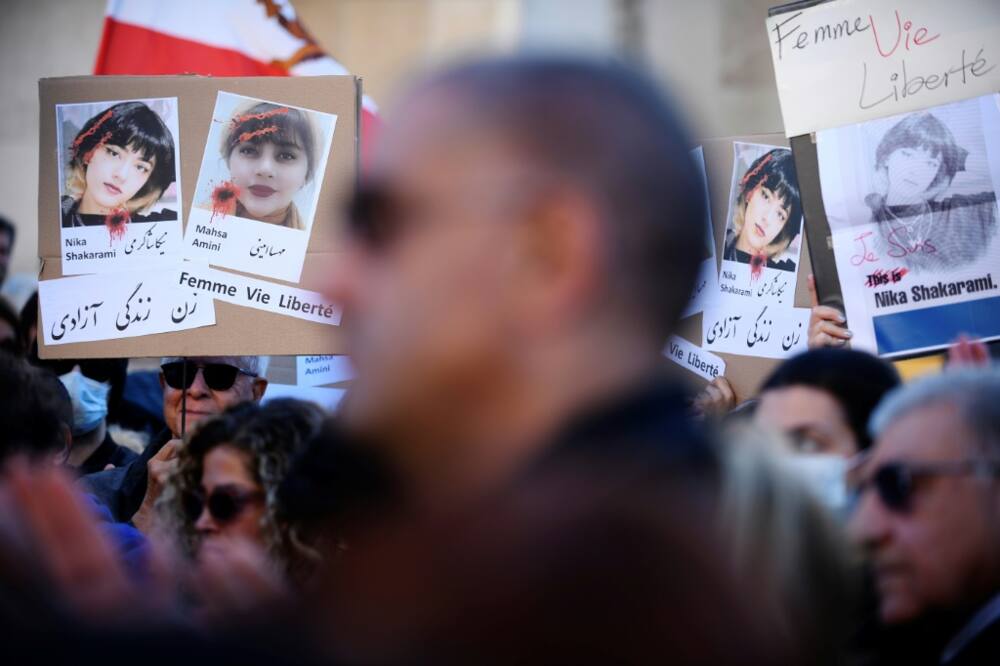 The faces of young women slain in the protests are seen at a rally