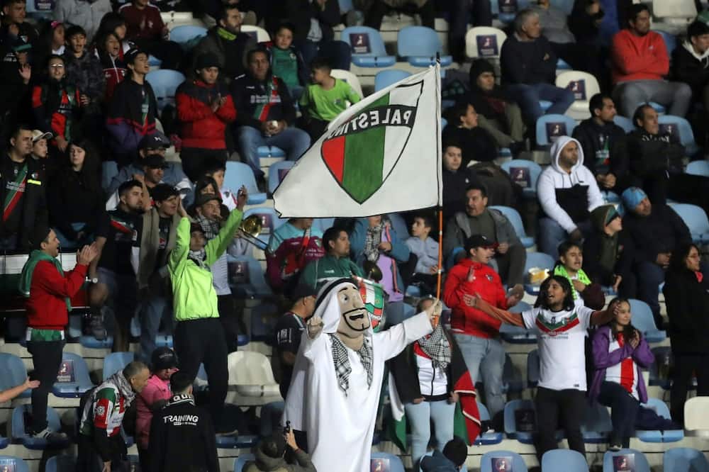 Francisco Muñoz (C), a 48-year-old janitor, cheers for his team Palestino wearing an Arab sheikh costume during the Copa Sudamericana match against Estudiantes de Merida in Rancagua, Chile, on April 18, 2023