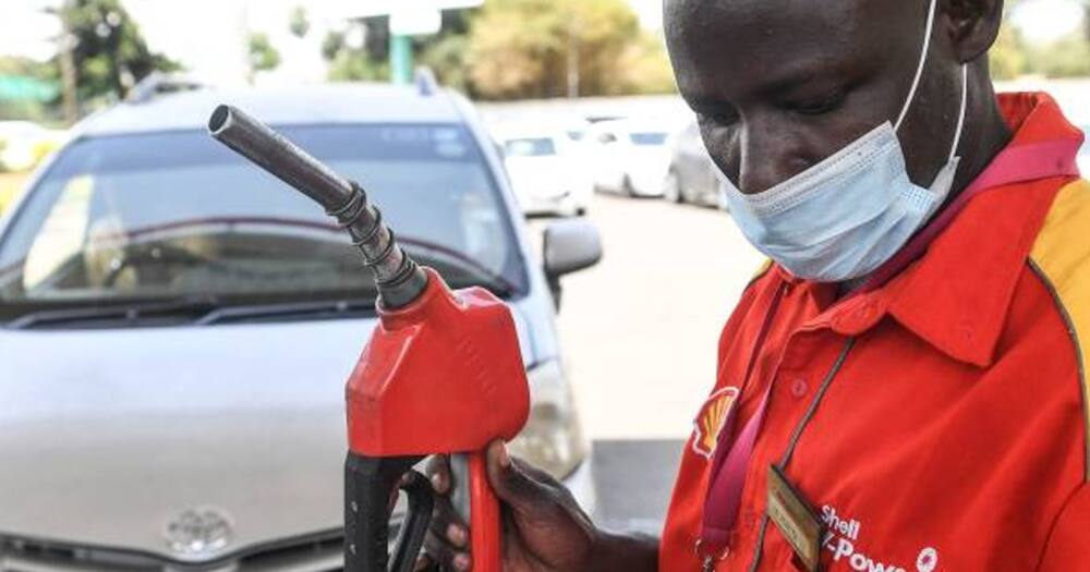 Shell petrol attendant holding a pump nozzle.