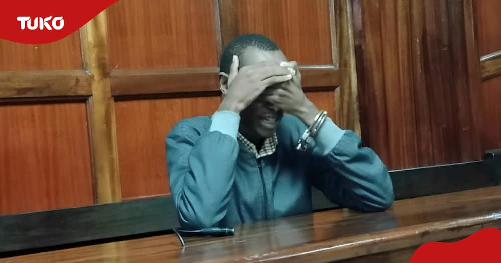 Benson Waziri covering his face after he was presented in court.