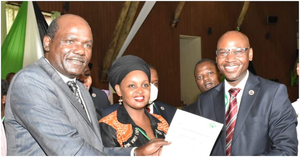 Walter Nyambane (r) being awarded a clearance certificate by IEBC chair Wafula Chebukati. Photo: IEBC.