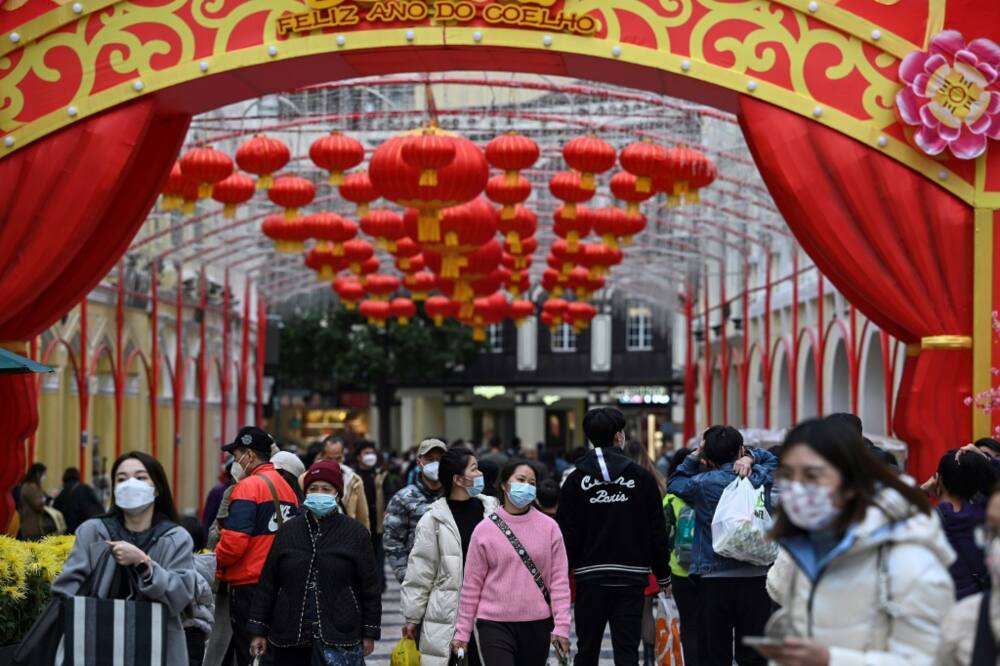 Tourists from mainland China stroll down a street in Macau