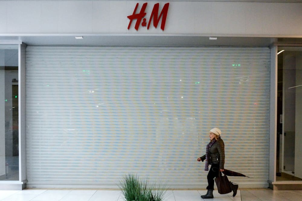A woman walks past a closed H&M clothing store at a shopping mall in Moscow in March 2022: Yale University business experts say Western sanctions are taking a serious toll on the Russian economy after its invasion of Ukraine