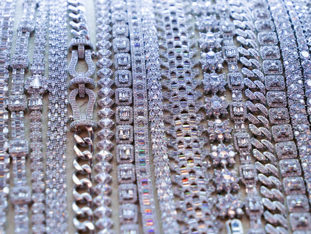 Silver bracelets and necklaces with diamonds in a row on display