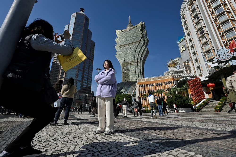 Chinese tourists take photos outside the Grand Lisboa Casino complex in Macau