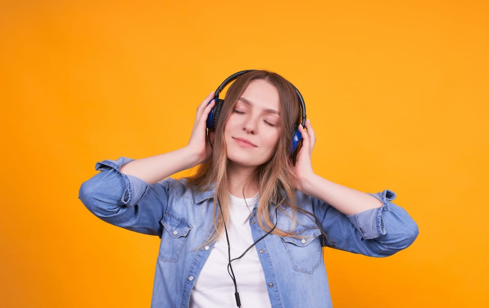 Young cute girl in headphones listens to music