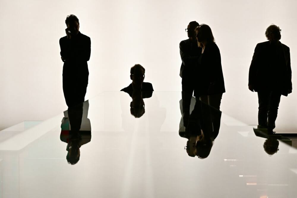 Visitors look at a glass table by Italian brand Santambrogiomila