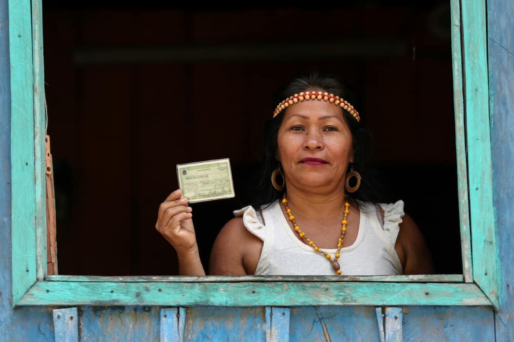 An indigenous Kambeba woman proudly displays her voter ID
