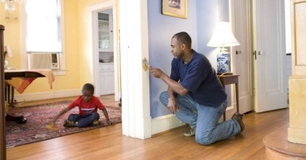 A father and son work on house chores together.