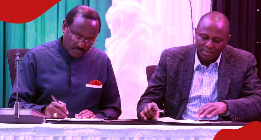 Kimani Ichungwa and Kalonzo Musyoka sign the bipartisan talk agreement.