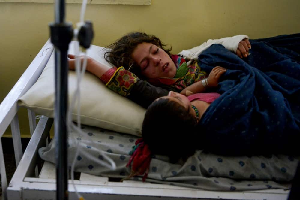 Two injured girls share a hospital bed in Sharan, capital of Paktika province