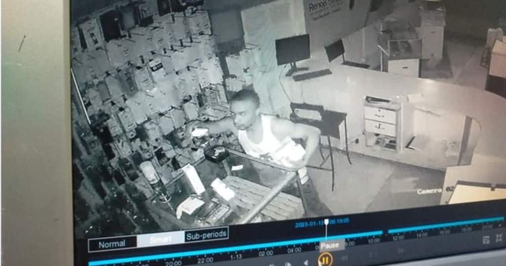 One of the suspects ransacks the shop.