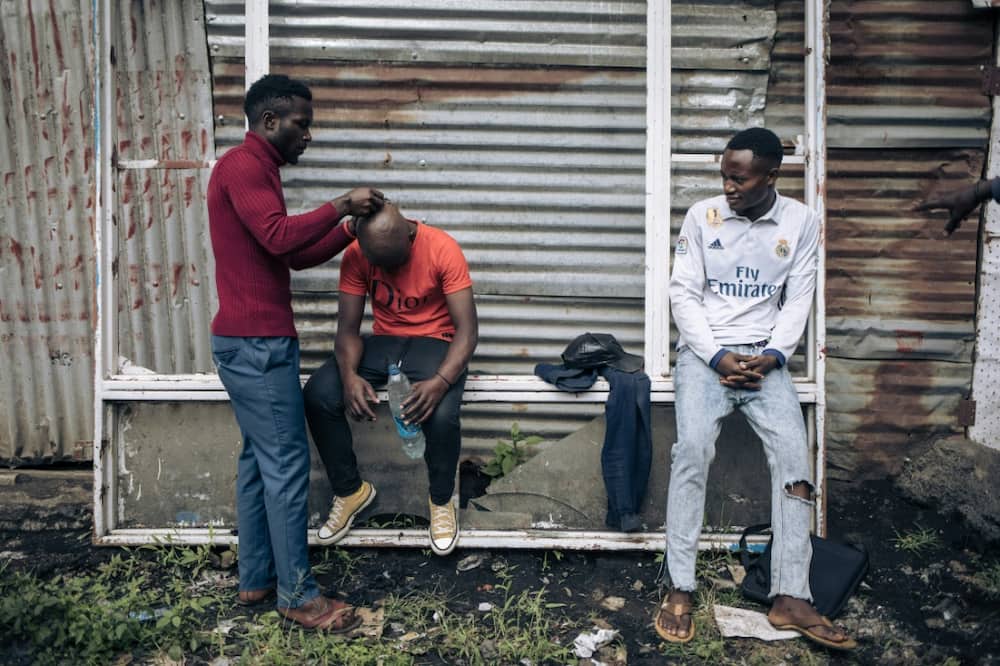 Would-be recruits to the Congolese army have their heads shaved near military base in Goma