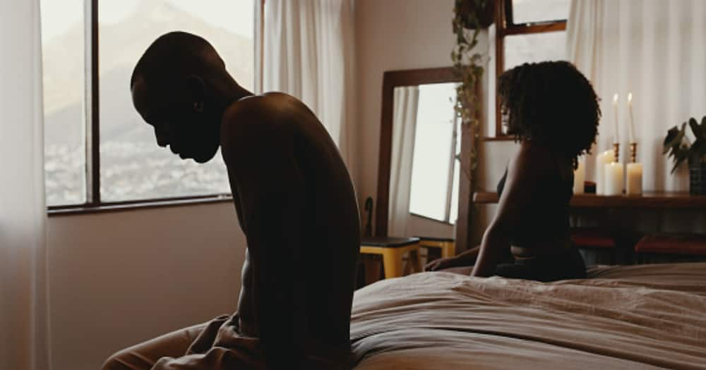 A couple sitting on bed after an argument.