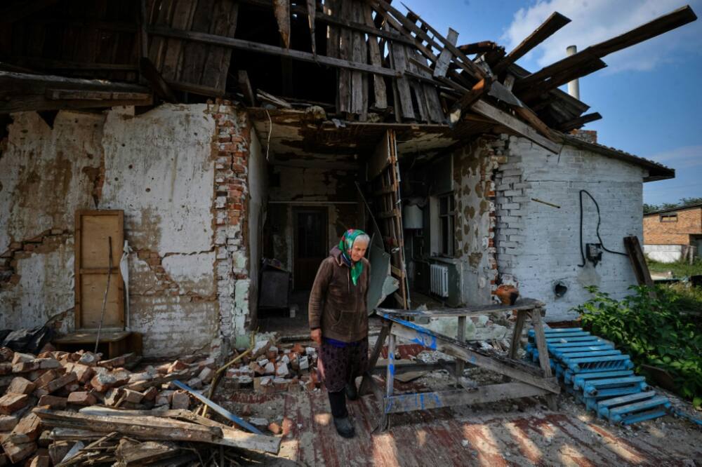 Tatyana, 69, walks in front of her destroyed house in the village of Lukashivka, Chernihiv region, on September 7, 2022, amid the Russian invasion of Ukraine.