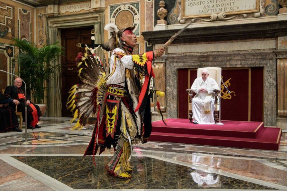 A member of a Canadian Indigenous delegation to the Vatican chants and dances during an audience with Pope Francis, who at the meeting pledged to visit Canada and apologize for abuses at state residential schools run by the church