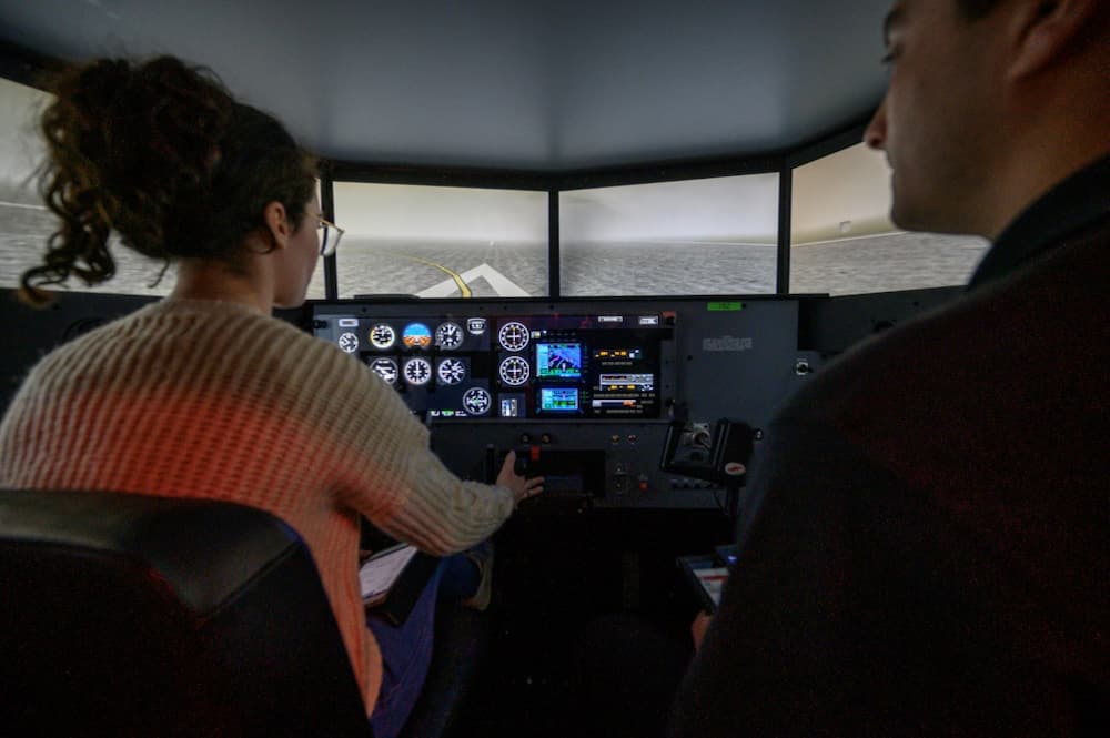 Student pilot Caitlyn Blanco (L) undergoes a training session in a flight simulator at the Farmingdale State College in Farmingdale, New York